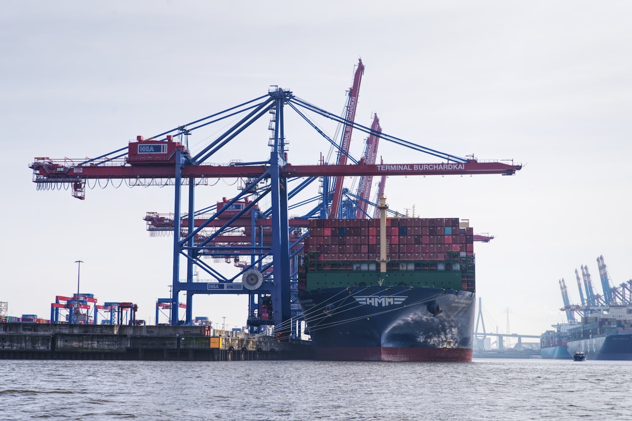 A row of stacked shipping containers at a port terminal. Illustrative photo.